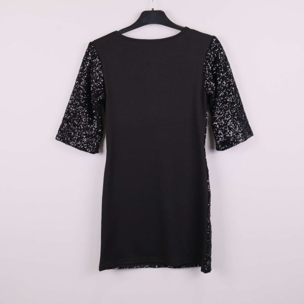 Baksidan av svart klänning med enfärgade partier och paljettärmar