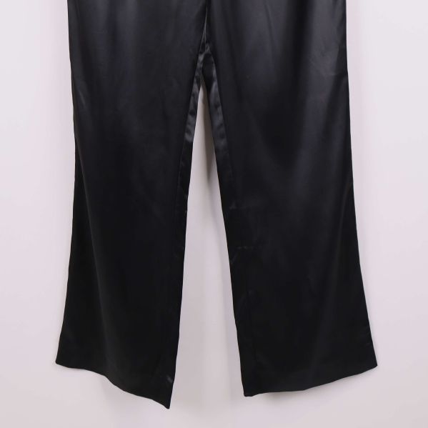 Närbild på benslut av svarta vida byxor