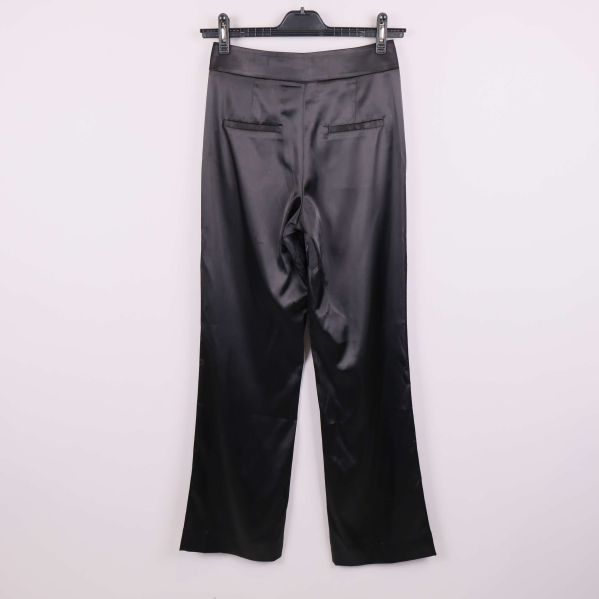 Baksida av svarta satinbyxor med raka ben