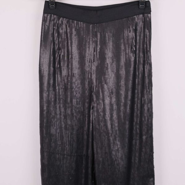 Övre delen av svarta paljettbyxor i fokus