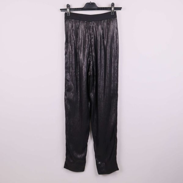 Baksidan av svarta paljettbyxor på galge