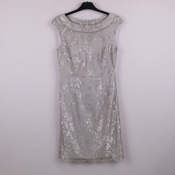 Silverfärgad spetsklänning sedd framifrån på galge