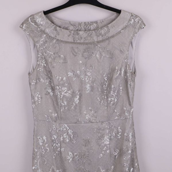 Närbild på överdelen av silverfärgad spetsklänning