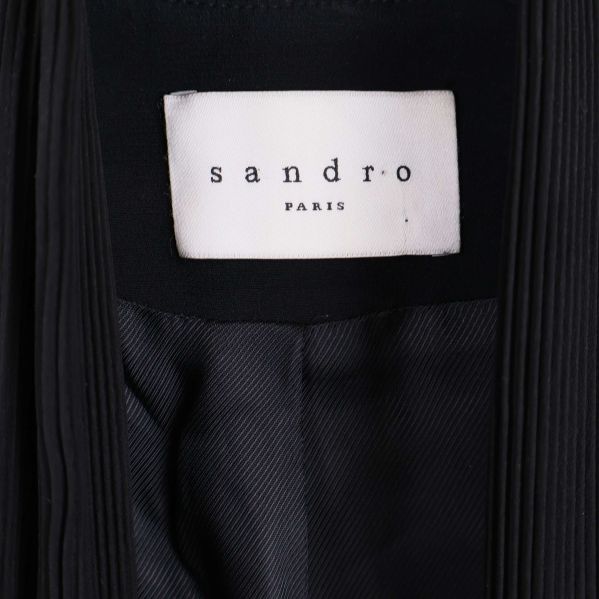 Närbild på Sandro Paris-märket i kavajen