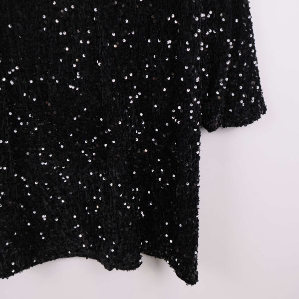 Detaljbild av paljetter på klänningens tyg