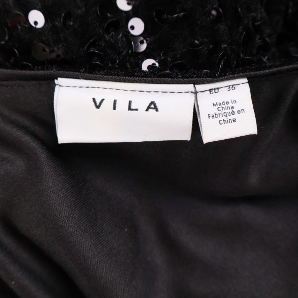 Närbild på vit etikett med texten VILA och storlek EU 36