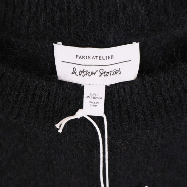 Närbild på etikett med & Other Stories och Paris Atelier