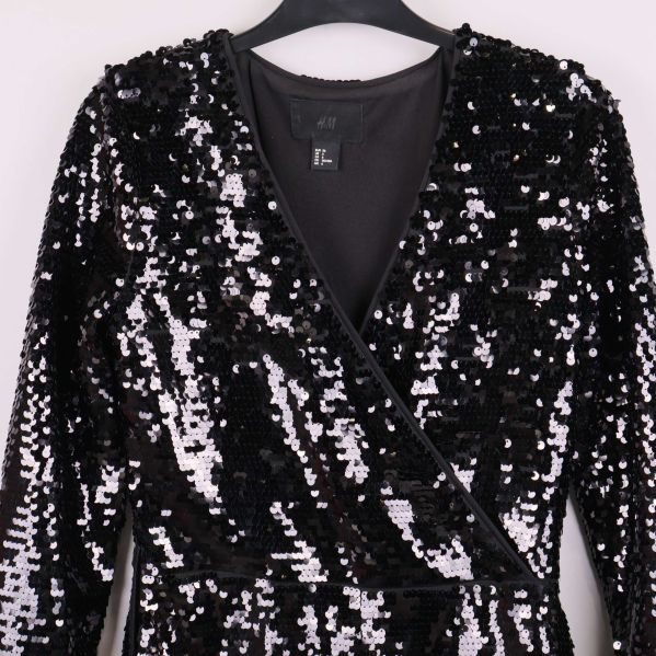 Omlott-detalj och paljetter på framsidan av jumpsuiten i närbild