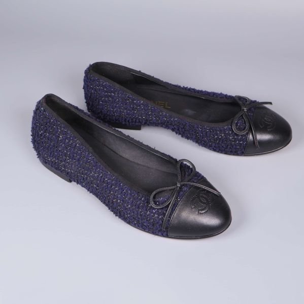 Ballerinaskor i mörkblå textil fotograferade snett uppifrån