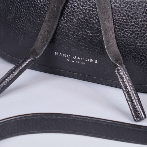 Närbild av Marc Jacobs-logotyp på väskans framsida