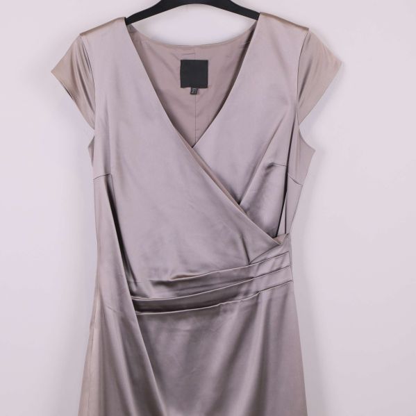 Närbild av omlottliv och draperad midja på klänningen