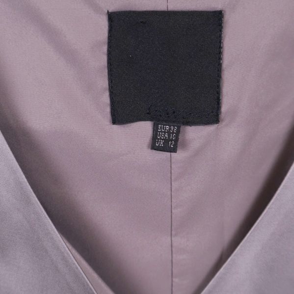 Närbild på storleksetikett och svart märkesskylt