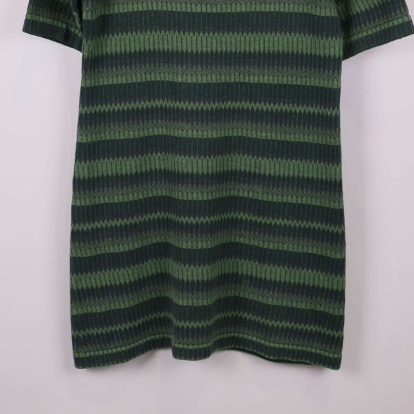 Nederdel av grön randig klänning i närbild