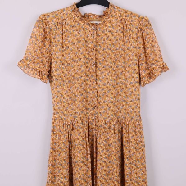 Närbild av överdelen på blommig klänning med rynkade detaljer