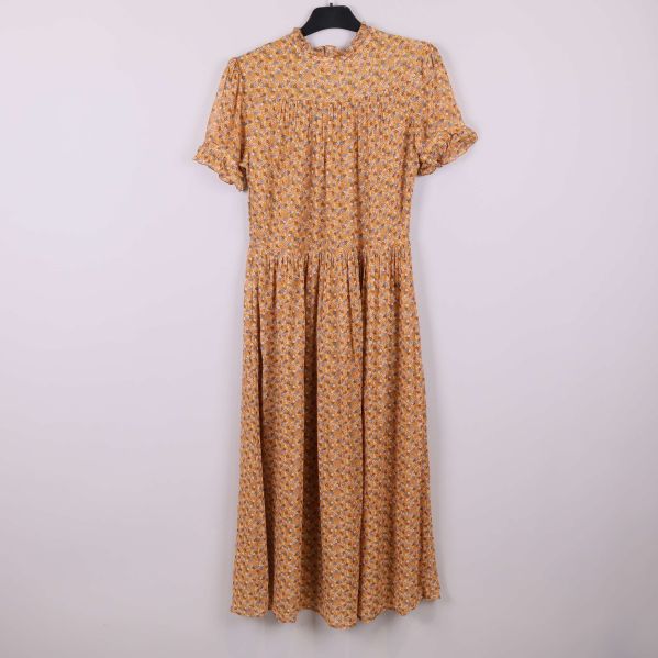 Blommig klänning sedd rakt framifrån på galge