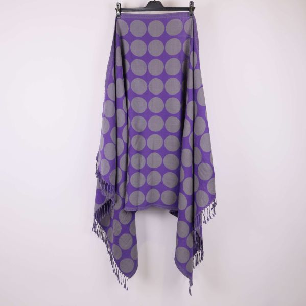 Prickig sjal i lila och grått draperad över galge