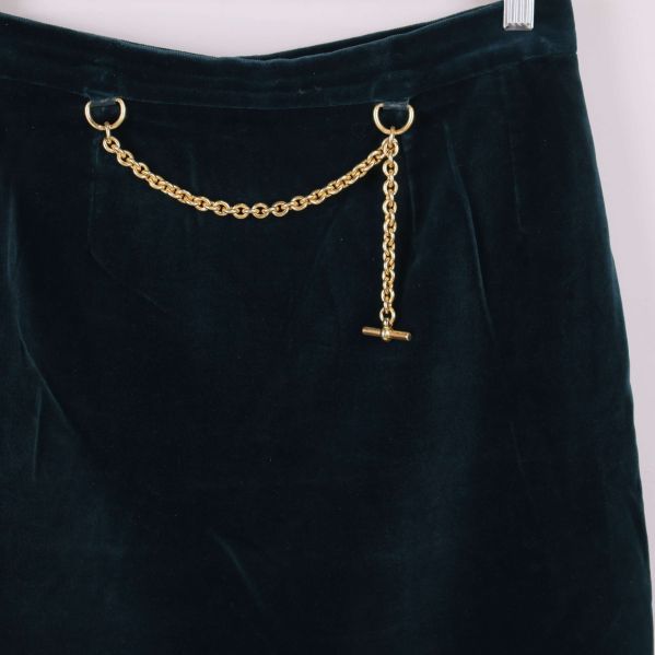 Detalj av guldfärgad kedja på sammetskjolens midja