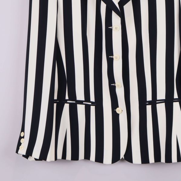 Nedre del av kavaj visar knappar och fickor