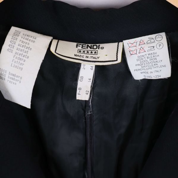 Närbild på Fendi-lapp och tvättråd inuti klänningen