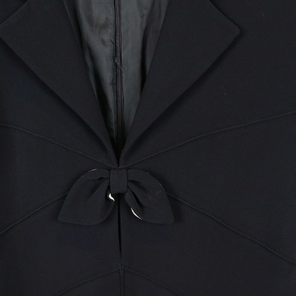 Närbild på rosettdetalj och krage framtill