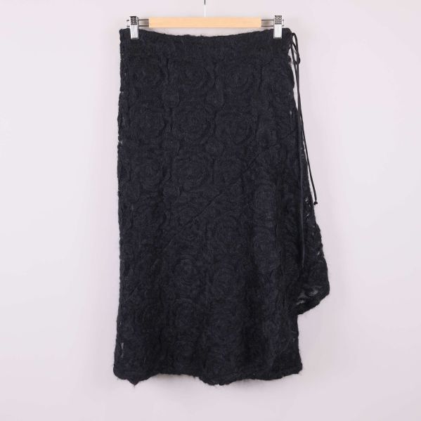 Svart kjol med rosstruktur hängande framifrån