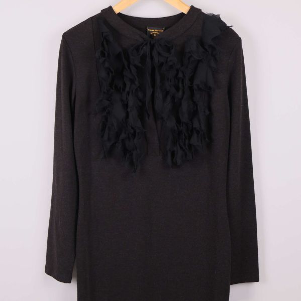 Framsidan av svart klänning med dekorativa applikationer