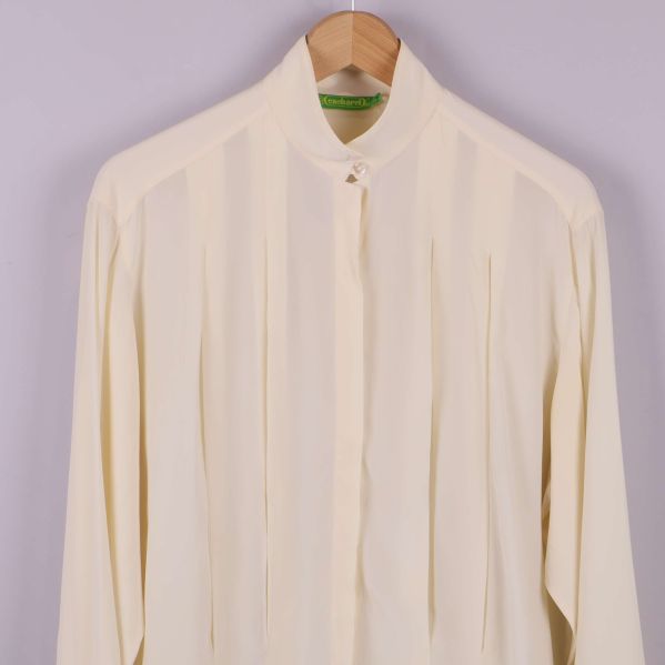 Framdel och krage på ljus blus med pärlknapp