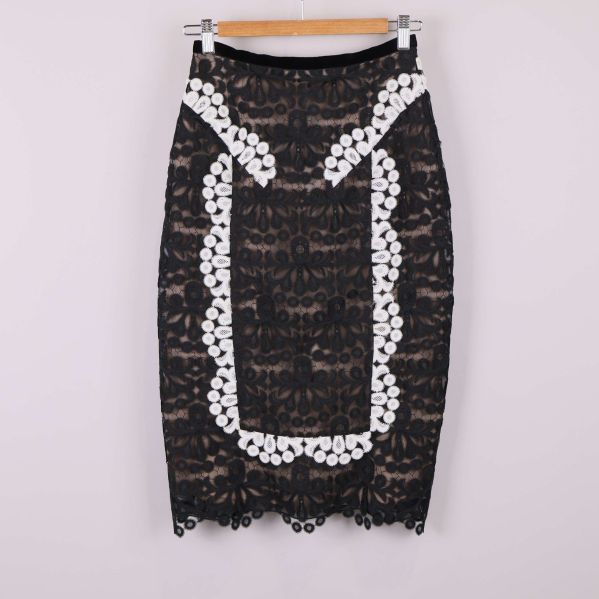 Framsidan av svart spetskjol med vita broderier