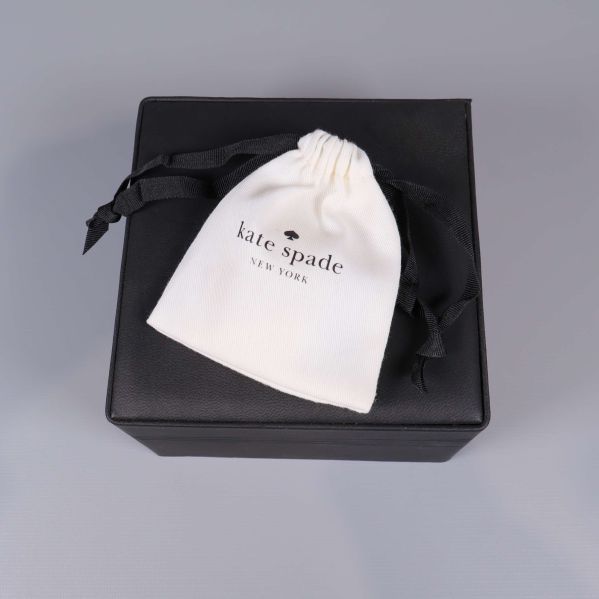 Vit Kate Spade-tygpåse på svart ask