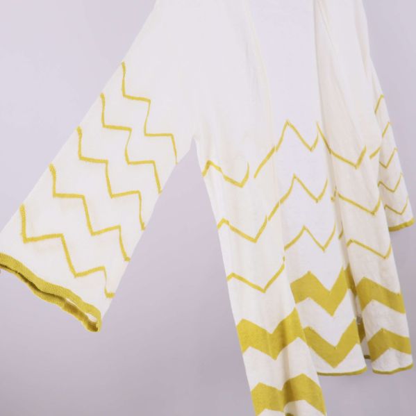 Närbild på ärm och gul zigzagdetalj på kofta