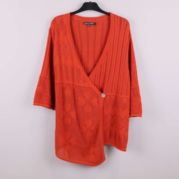 Orange stickad kofta med djup v-ringning på galge