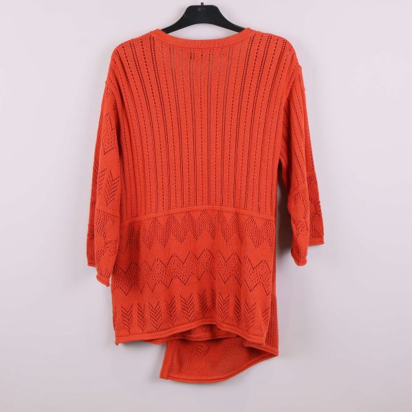 Baksidan av orange stickad kofta med olika mönster