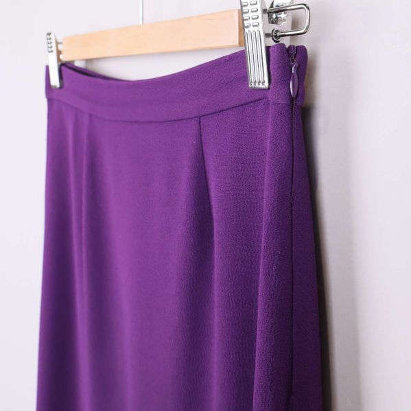 Sidsöm och dragkedja på lila kjol i närbild