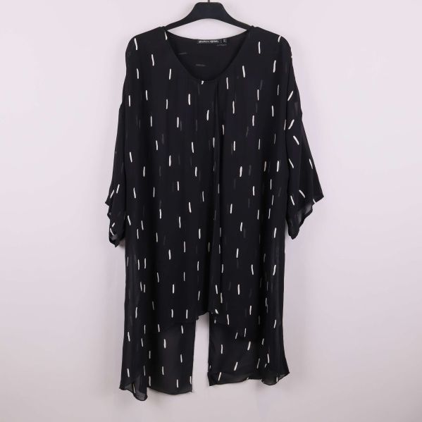 Svart tunika med vitt grafiskt mönster på galge, framifrån