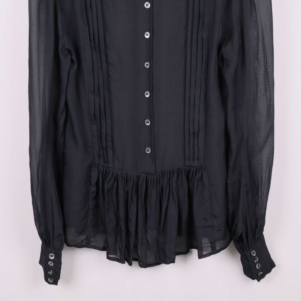 Nederkant och ärmslut på svart blus
