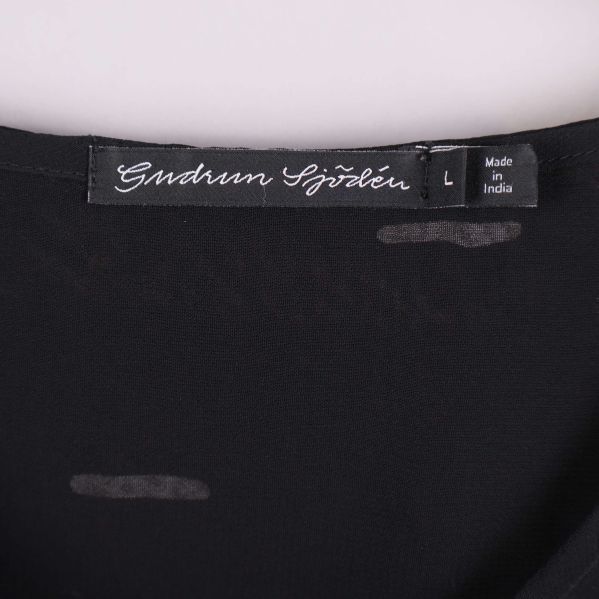 Nära bild på etikett från Gudrun Sjödén vid halsen