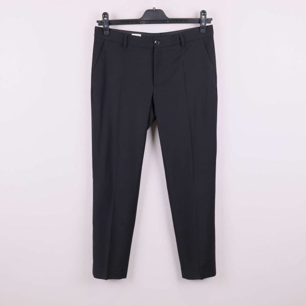 Svarta raka byxor på galge mot vit bakgrund