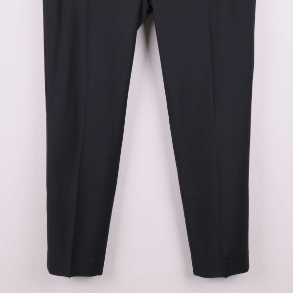 Närbild på benslut på svarta raka byxor