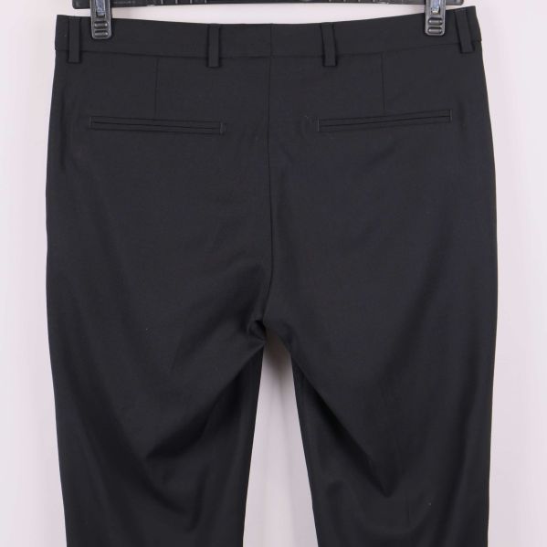 Närbild bakfickor på svarta raka byxor