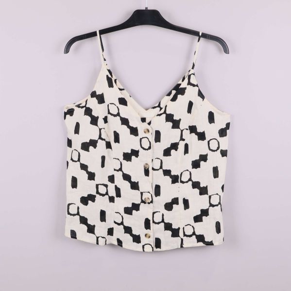 Framsidan av linne med svarta grafiska former och knappar