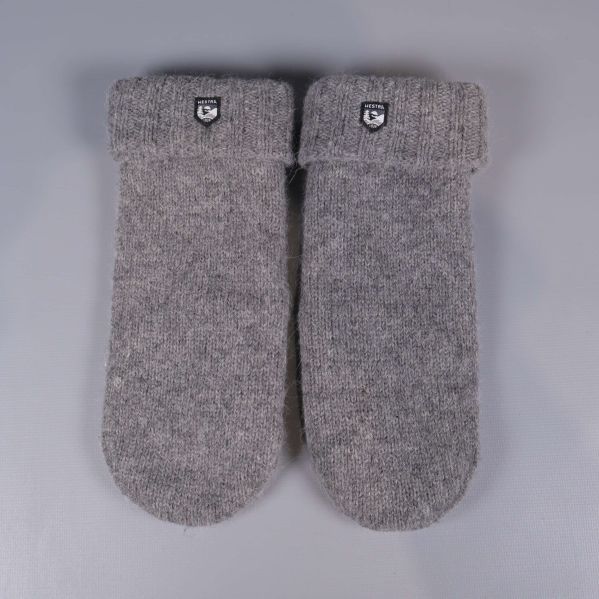 Ett par grå stickade tumvantar med Hestra-märke framtill