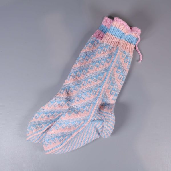 Stickade sockor i rosa och blått, liggande snett