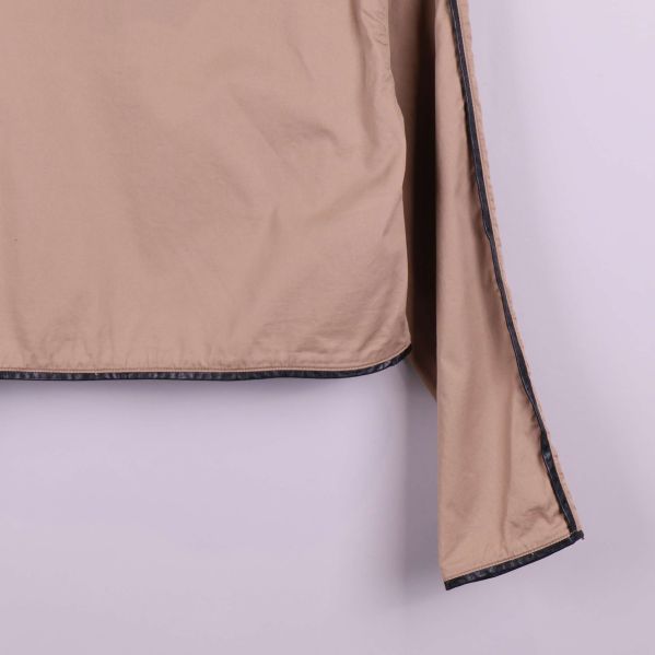 Ärmslut på beige jacka med svart kant