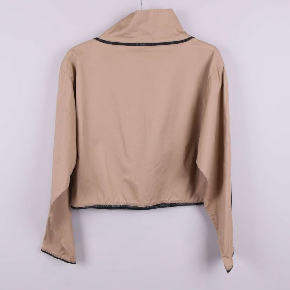 Baksidan av beige jacka med svart kant