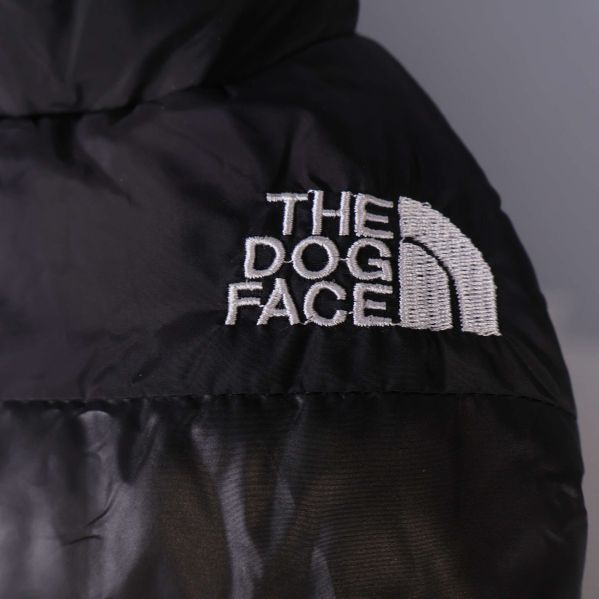 Närbild på vit broderad The Dog Face logga