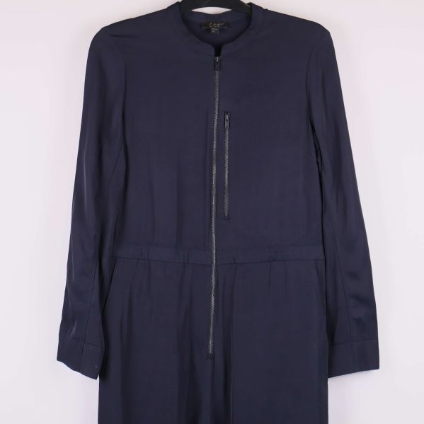 Närbild framtill på jumpsuitens dragkedja och bröstficka