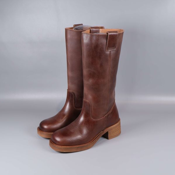 Ett par höga bruna läderstövlar i profil mot grå bakgrund