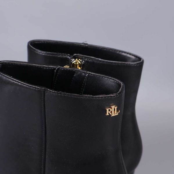 Närbild på RL-detalj i guld på boots