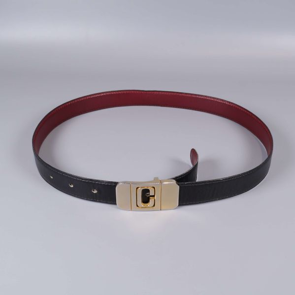 Bälte sett rakt ovanifrån med röd insida och spänne