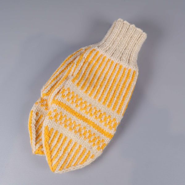 Stickad tumvante i gräddvitt och gult på grå bakgrund